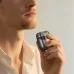Close view of portable electric shaver used on chin highlighting compact design for precise grooming