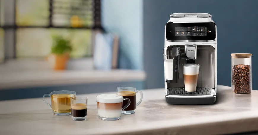 Angled view of a modern white and black Philips EP3343/31 espresso machine on a kitchen counter with prepared coffee cups.